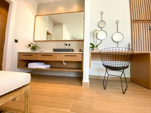 a bathroom with a vanity with a mirror and a chair at Villa Lydia I Superb views, two pools, next to the city in Kissamos