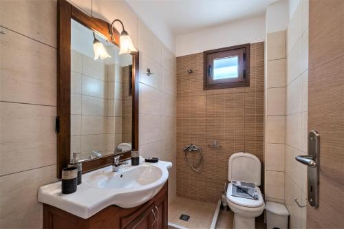 a bathroom with a sink and a toilet at Villa Zeus in Kaloniktis