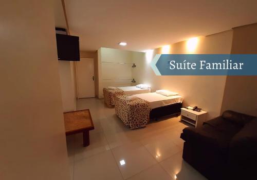 a hotel room with two beds and a couch at Biss Inn Hotel in Goiânia