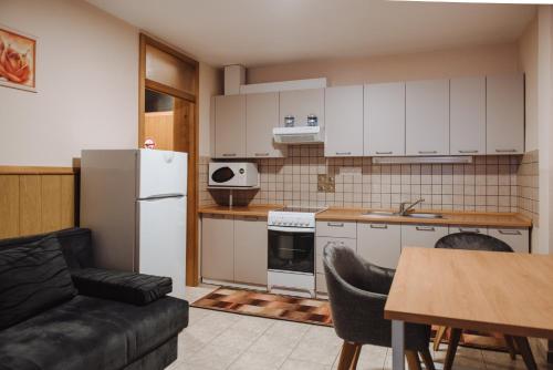 a kitchen with a refrigerator and a table with chairs at Gostisce Ulipi in Slovenske Konjice