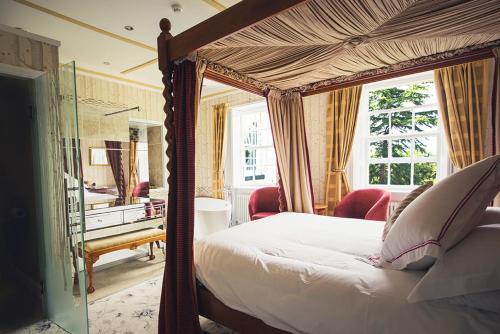 a bedroom with a canopy bed and a desk at Hickman Hill Hotel in Gainsborough