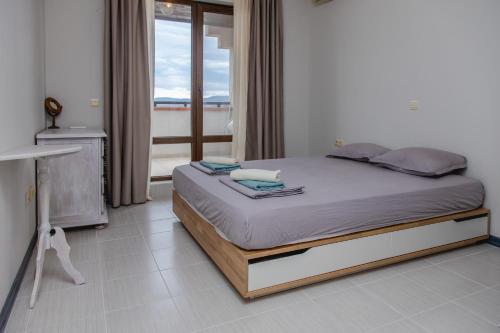 a bed in a room with a window at Lovely 3BD flat with PARKING and SEA VIEW by Flаt Manаger in Chernomorets