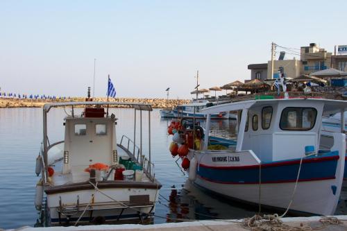 two boats are docked at a dock in the water at Porto Sisi Hotel Apartments in Sissi