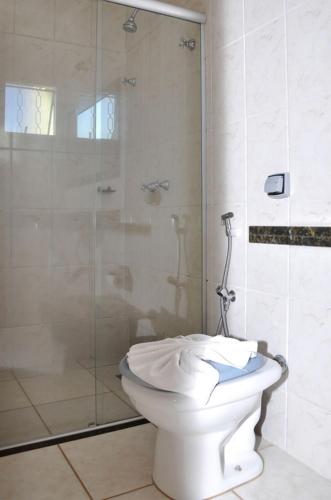 a bathroom with a toilet and a glass shower at Hotel Carolina 2 - próximo a Universidade de Uberaba uniube - ao Aeroporto Fórum De uberaba - hospital Mario Palmeirio ao Hospital São Marcos e hospital Regional in Uberaba