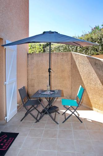- une table et des chaises sous un parasol sur la terrasse dans l'établissement Studio Di Felicita, à Cauro
