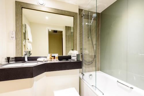 a bathroom with two sinks and a mirror at Holiday Inn Portsmouth, an IHG Hotel in Portsmouth