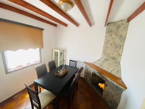 a dining room with a table and a fireplace at La Casa de Vilaflor in Vilaflor