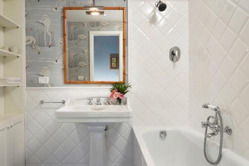 een witte badkamer met een wastafel en een bad bij Punta Ala Sea View Apartments in Punta Ala
