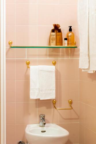 a bathroom with a sink and a toilet and towels at Nevesole Folgarida Resort Aparthotel in Folgarida