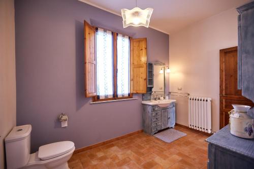 een badkamer met een toilet, een wastafel en een raam bij Agriturismo Podere Casa al Vento in Montepulciano