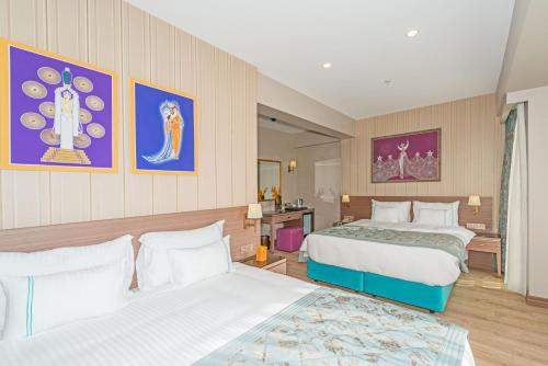 a hotel room with two beds and paintings on the wall at Taximist Hotel in Istanbul