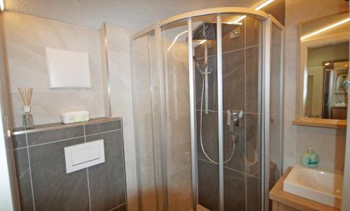 uma casa de banho com um chuveiro e um lavatório. em Apartment Fleißner em Dienten am Hochkönig