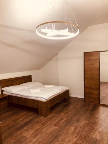 a bedroom with a bed and a light fixture at Penzion a Restaurace v Zátiší in Horní Lhota