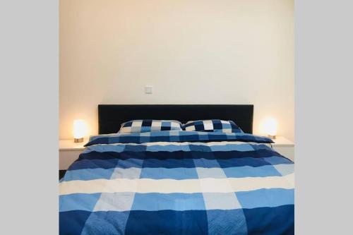 a blue and white bed with two pillows on it at Pearl Studio Apart - King Bed - Netflix - Projector - Fast Wi-Fi in Trier
