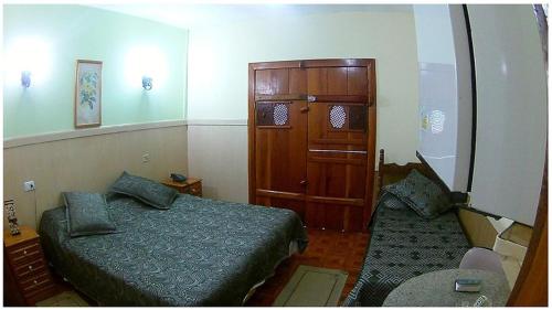 a bedroom with a bed and a cabinet and a couch at Caparaó Parque Hotel in Caparaó Velho