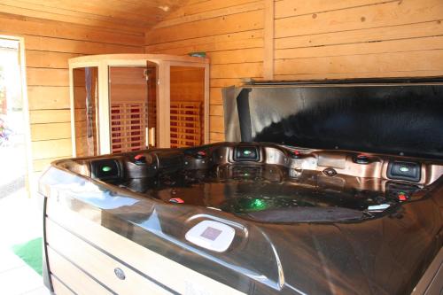 a bath tub in a room with a tv at La Parenthèse Vosgienne in Bussang