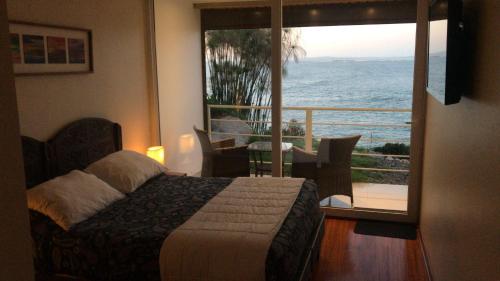 a bedroom with a bed and a view of the ocean at Laura del Mar Hotel Boutique in Concón