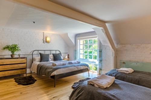 a bedroom with two beds and a window at Luxury Victorian school with views of Harbour in Fowey