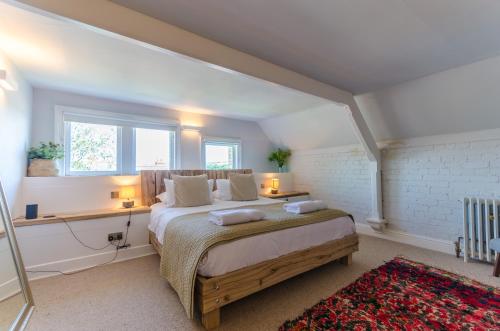 a bedroom with a bed and a desk and a window at Luxury Victorian school with views of Harbour in Fowey