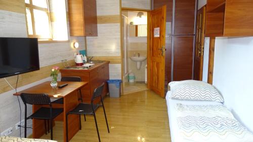 a small room with a desk and a bed and a bathroom at Noclegi "Marek i Karolina" in Cieszyn