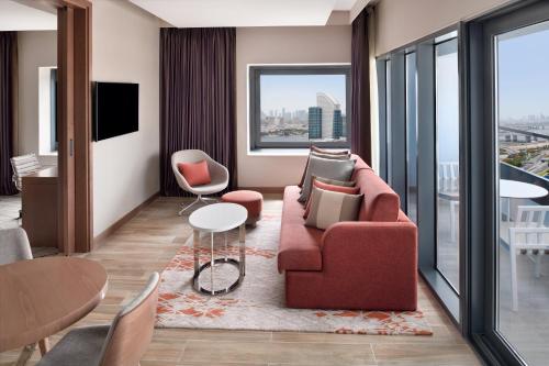 a living room with a red couch and a table at Holiday Inn & Suites - Dubai Festival City by IHG in Dubai