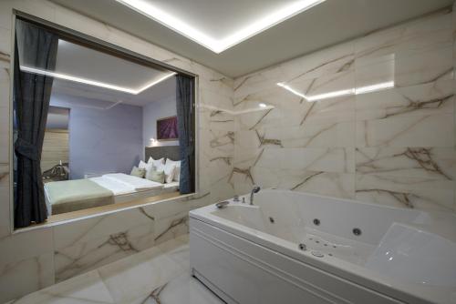 a bathroom with a tub and a sink and a mirror at Hotel Sunce in Soko Banja