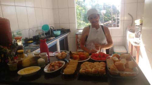 een vrouw die in een keuken staat en eten klaarmaakt bij Pousada Encantadas in Pontal do Paraná