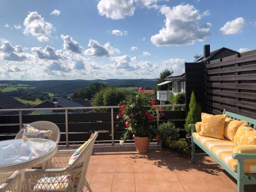 a patio with a couch and a table on a balcony at Odenwald Chalet in Erbach