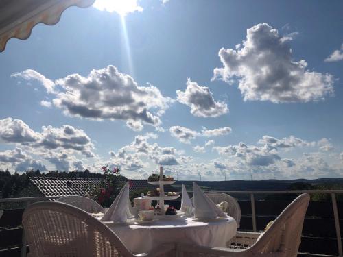 una mesa con sillas y un cielo con nubes en Odenwald Chalet en Erbach