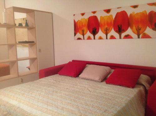 a bedroom with a bed with two red pillows at RESORT VILLAGE AQUA MARINA FAMILY - Daily Rooms Tidying - CocktailsBar- Pet Friendly - with Hypermarket - Delivery Restaurant-Pizzeria - Room Breakfast with supplement - Ultra Fast Wi-Fi - Play Area for children - Olympic Swimming Pool - Parking in Caorle
