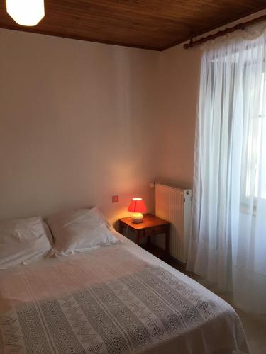 um quarto com uma cama e uma janela com um candeeiro em Gîte des Infruits em Les Estables