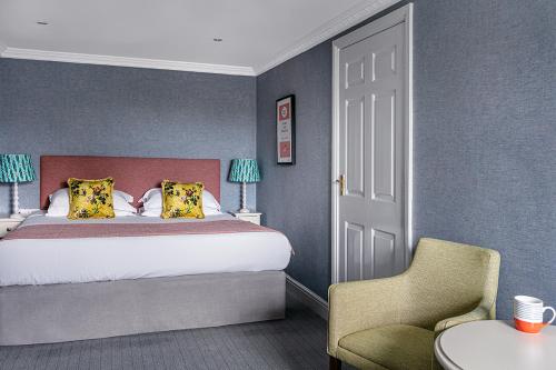 a bedroom with a bed and a chair and a table at Craig Manor in Bowness-on-Windermere