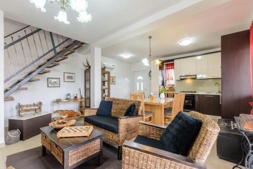 een woonkamer met rieten meubels en een keuken bij Villa Daisy in Dugobabe