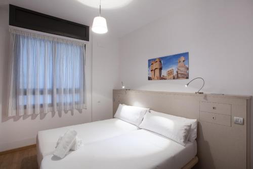 a bedroom with a white bed with white pillows at Casa Codina in Barcelona