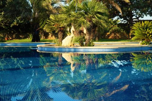 a reflection of a statue in a swimming pool at Agroturismo Finca Sa Tanca in Cala d´Or