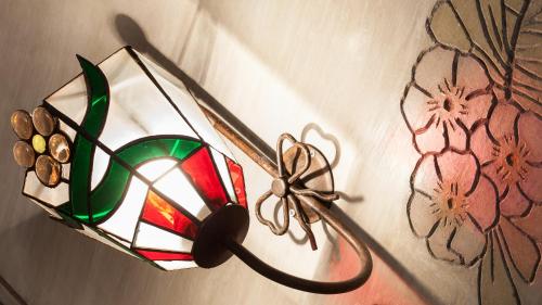 a glass candle holder on a wall with flowers at Casa Codina in Barcelona