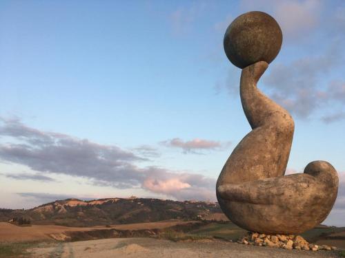 a statue of a person balancing a rock on their head at Agriturismo Fattoria Lischeto in Volterra