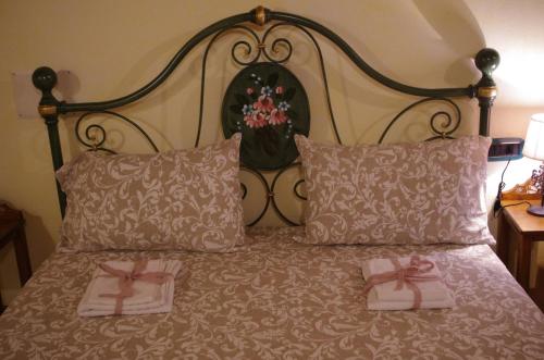 a bed with two pink towels on top of it at Casa De Ajala - B&B de Charme in Antica Dimora totalmente ristrutturata e dotata di tutti i confort Bagni privati Spazio living Patio esterno Ambienti climatizzati Degustazioni prodotti locali in Làconi