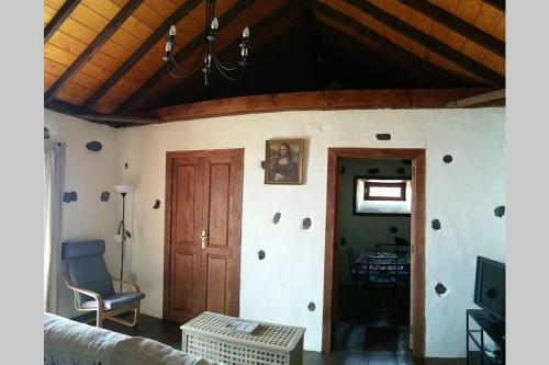 a living room with a wooden ceiling and a chair at "VILLA SERVANDA" - Casa Canaria construida a PRINCIPIOS DEL SIGLO XIX in Puntagorda