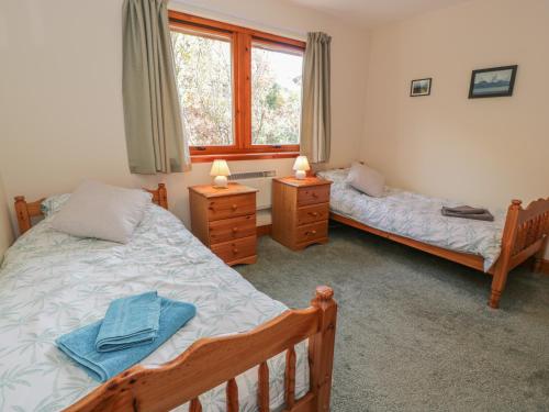 1 dormitorio con 2 camas y ventana en Taigh Na Talia - 2 Sandholm, en Mallaig