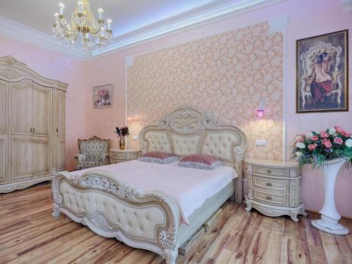 um quarto com uma cama branca e um vaso de flores em Rose em Mariánské Lázně