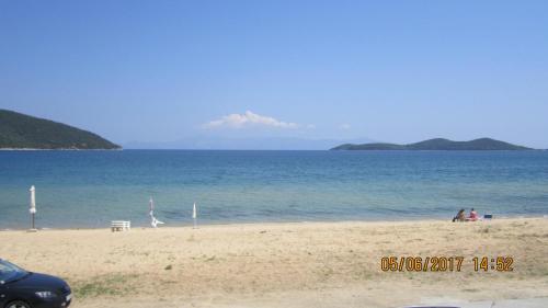 a group of people on a beach with the ocean at Peramos Rent House in Néa Péramos