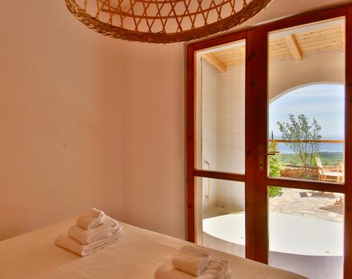 een kamer met een raam met handdoeken op een bed bij LA VEDETTA dell’Eden by KlabHouse in Domus de Maria