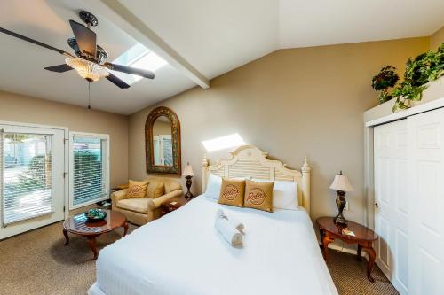a bedroom with a white bed and a couch at Sandals Inn | Spa Suite & Oceanside Cabana in Cannon Beach