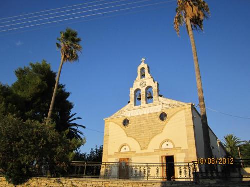 a church with two palm trees in front of it at Aloe & Lotus Villas in Prinés