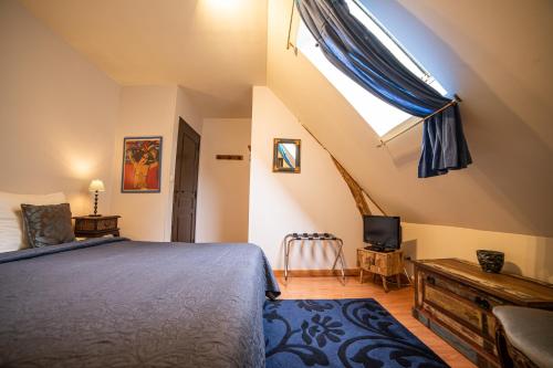 a bedroom with a bed and a skylight at Domaine De La Tour in Saint-Pierre-Canivet