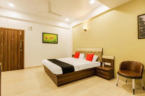 a hotel room with a bed and a chair at Hotel Om Inn - Talegaon Dabhade in Talegaon Dābhāde