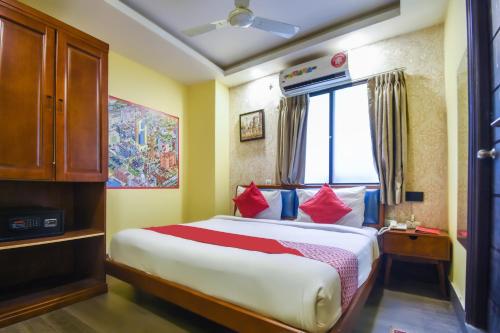 um quarto com uma cama grande e almofadas vermelhas em Kiaan Inn em Calcutá