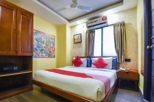 a bedroom with a large bed with red pillows at Kiaan Inn in Kolkata