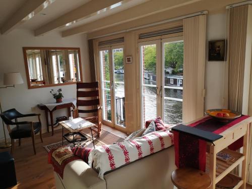 a living room with a couch and a large window at Canal View in Amsterdam